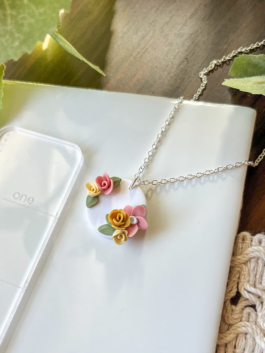 Small white medallion necklace with pink and yellow flowers | multiple metals