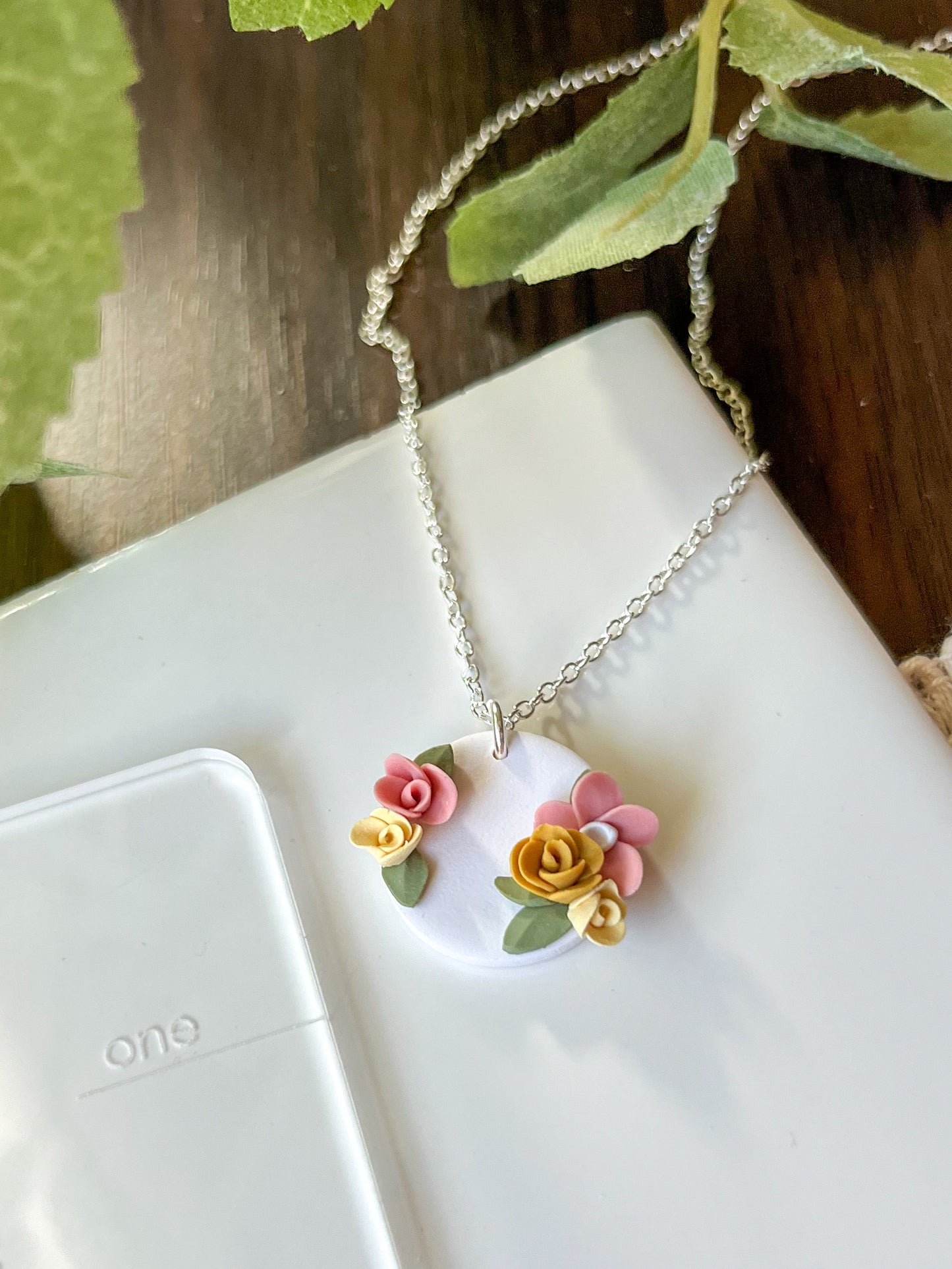 Small white medallion necklace with pink and yellow flowers | multiple metals